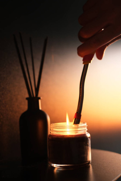 Mies sytyttää kynttilän. käsite kodikas koti rentouttava tunnelma. Rentoutuminen ja aromaterapia - Valokuva, kuva