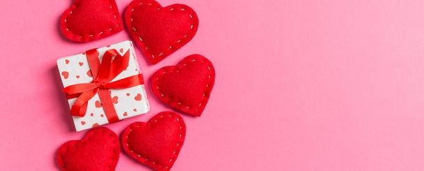 Vista superior de cajas de regalo y corazones textiles rojos sobre un fondo colorido. Concepto de San Valentín con espacio para copiar. - Foto, Imagen