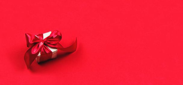 Christmas gift and Valentine's day in wrapping paper on a red background - Foto, imagen
