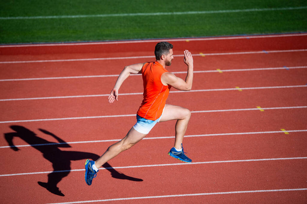 Energy inside. runner on racetrack. challenge and competition. marathon speed. sport athlete run fast to win. successful fitness sprinter. male coach on stadium running track. endurance and stamina - Fotografie, Obrázek