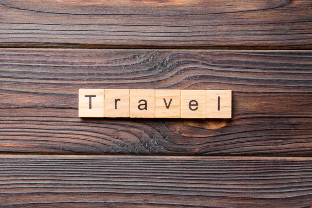 木のブロックに書かれた旅行の単語。あなたのデザイン、コンセプトのセメントテーブル上の旅行テキスト. - 写真・画像