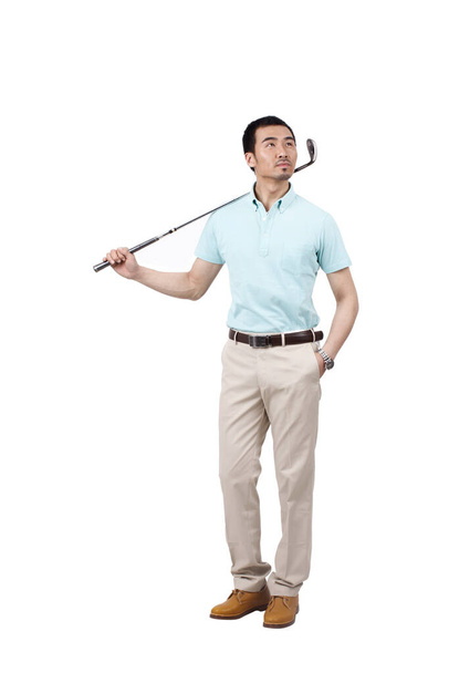 Young man wearing a suit and golfing - Fotó, kép