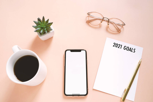 2021 New year resolutions concept on flat lay photo of workspace desk with smartphone, coffee, paper note with copy space background, minimal style  - Photo, Image
