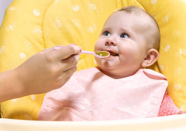 Maman nourrit bébé avec de la purée de légumes. Concentration sélective. Produits alimentaires. - Photo, image