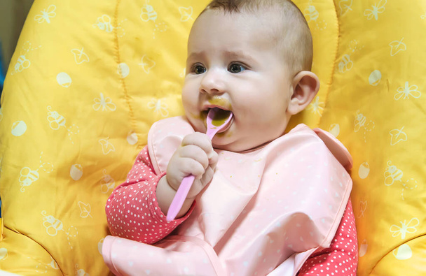 Ребенок ест овощное пюре. Выборочный фокус. Еда. - Фото, изображение