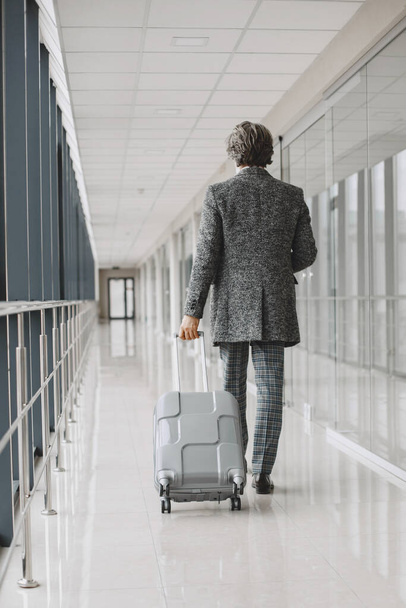 Senior businessman with travel suitcase in airport - Foto, immagini