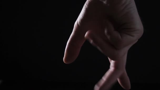 een mensenhand klemt zich in een vuist in woede op een zwarte achtergrond - Video