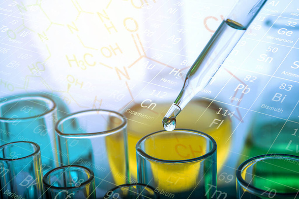 Tropfen chemischer Flüssigkeit auf das Reagenzglas mit Laborgläsern Hintergrund. Forschungs- und Entwicklungskonzept für Wissenschaft oder Chemie.  - Foto, Bild