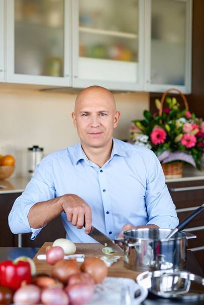 felnőtt brutális férfi a konyhában ételt készít - Fotó, kép