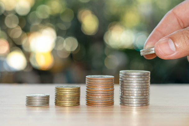Empresários estão empilhando moedas para economizar dinheiro para seus investimentos futuros. - Foto, Imagem