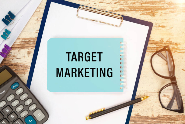 TARGET MARKETING is written on a notepad on an office desk with office accessories. - 写真・画像
