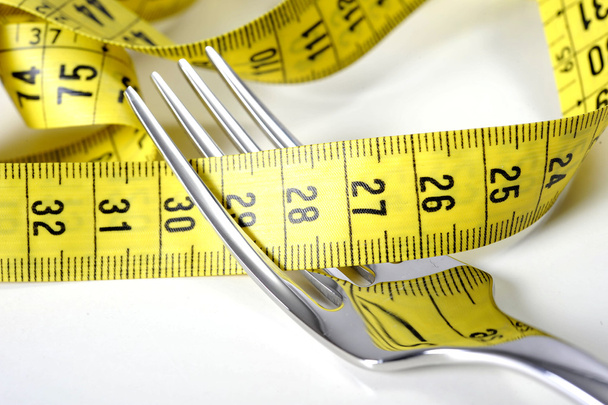 ダイエットと太り過ぎの概念の測定テープでラップ シルバー フォーク  - 写真・画像