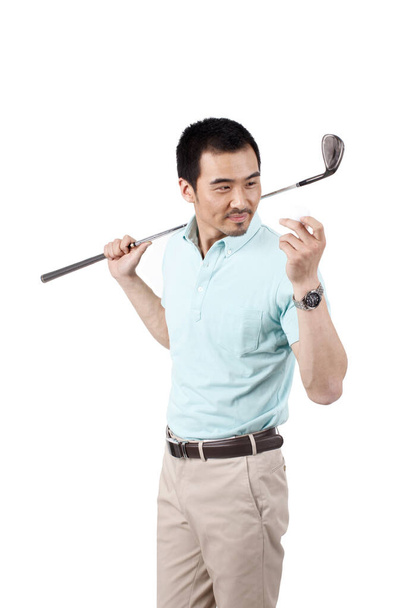 Young man wearing a suit and golfing - 写真・画像