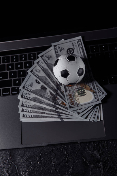 賭け、スポーツ賭博、ブックメーカー。ノートパソコンのキーボードのサッカーボール。垂直画像 - 写真・画像