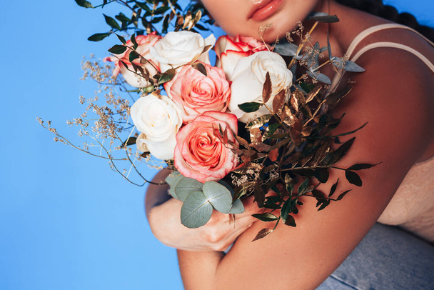 Young woman holding a beautiful bouquet of white roses in her hands, woman hugging a bouquet of roses in a holiday. - Photo, Image