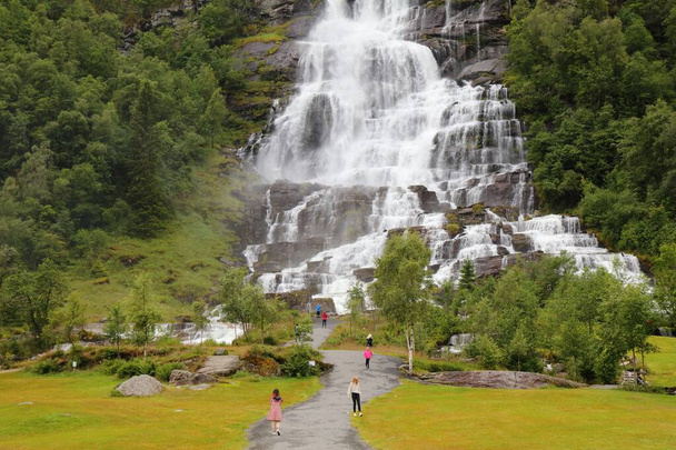 SKULESTADMO, NORWAY - JULY 30, 2020: People visit Tvindefossen waterfall in Skulestadmo, Norway. Norway had 8.8 million foreign visitors in 2015. - Foto, Imagen