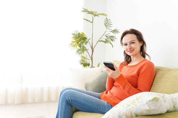 young woman using a smartphone at home - Foto, Bild