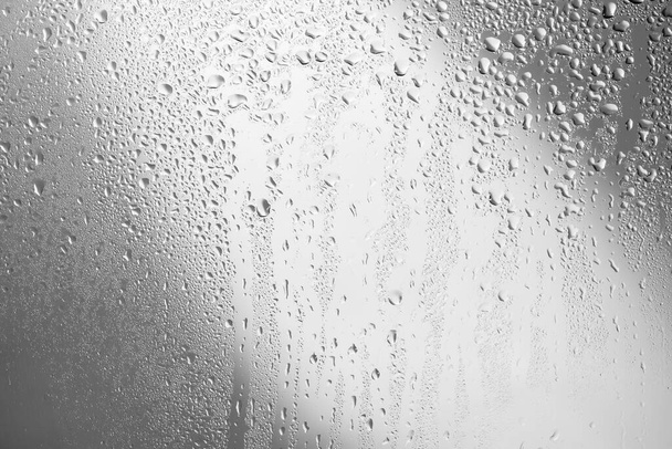gouttes d'eau sur le verre sur un fond gris - Photo, image