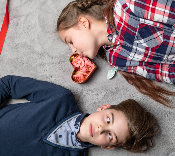 Engraçado irmã e irmão ficar fora línguas para o outro, adolescentes felizes e sorridentes com biscoitos em forma de coração - Foto, Imagem