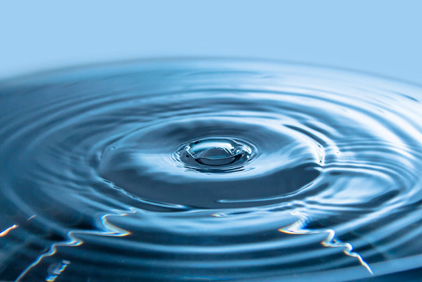 Víz splash hátterek közel.Korona kék víz.VízcseppFagyasztott fröccsenő mozgás.Lassú csöpögő folyadék légbuborékok. Természeti háttér vagy tapéta.Fagyasztott folyadék fröccsenés - Fotó, kép