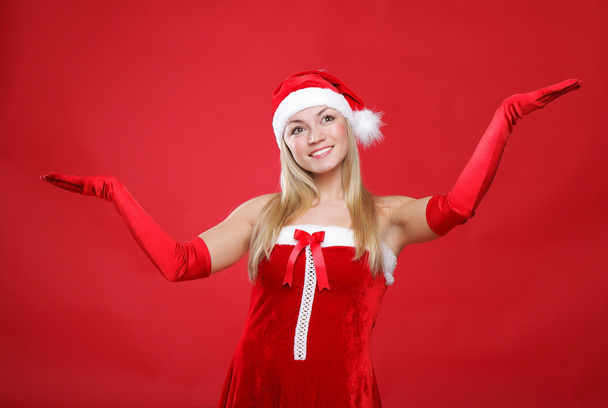 Young girl dressed as Santa Claus on a red background - Valokuva, kuva