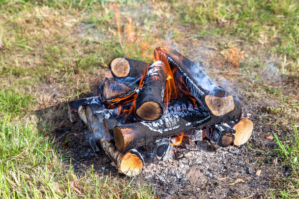 キャンプファイヤーで暖かい火が燃えるのを閉じる - 写真・画像