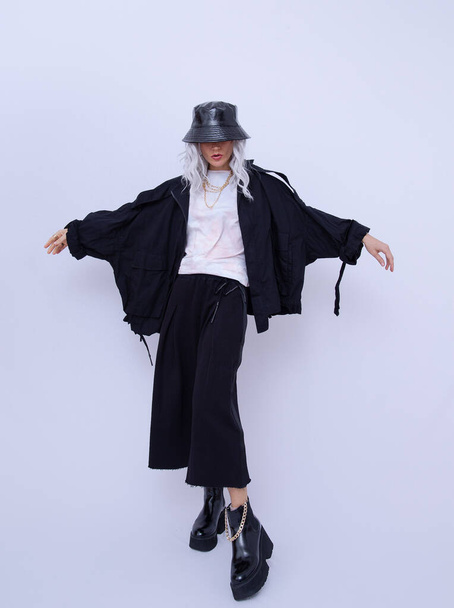Studio Fashion Portrait Of Model Wearing black and White Street Clothes and stylish accessories. Bucket hat and trendy platform boots. Minimalist concept - Fotó, kép