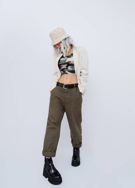 Portrait of young blond woman wearing military fashionable street style clothing and trendy platform boots. Minimalist fashion - Φωτογραφία, εικόνα