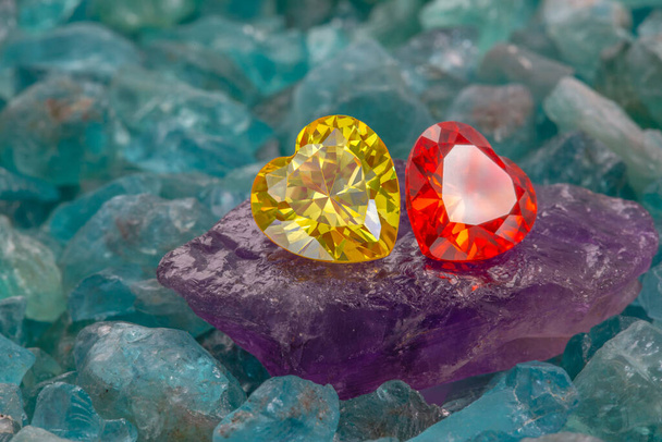 Geel hart diamant en Rode robijn hart diamant op ruwe hemel blauwe edelstenen.sieraden in hartvorm zijn mooi cadeau voor Valentijnsdag - Foto, afbeelding