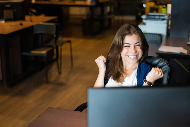 Joyful woman at her desk in the office - Fotografie, Obrázek