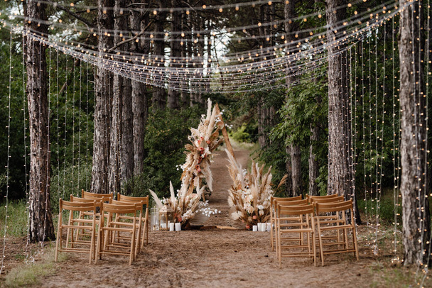 zone de cérémonie de mariage avec des fleurs séchées dans une prairie dans une forêt de pins brun - Photo, image