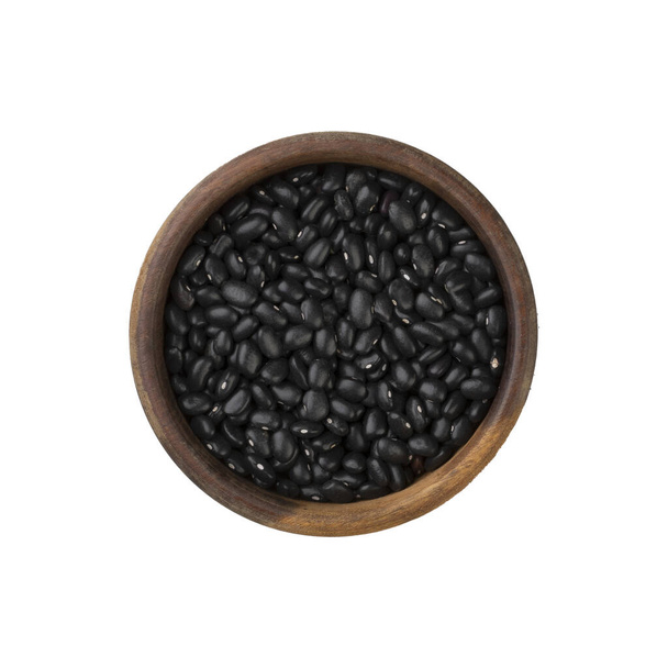 Raw black beans on a wooden bowl isolated over white background. - Foto, Bild