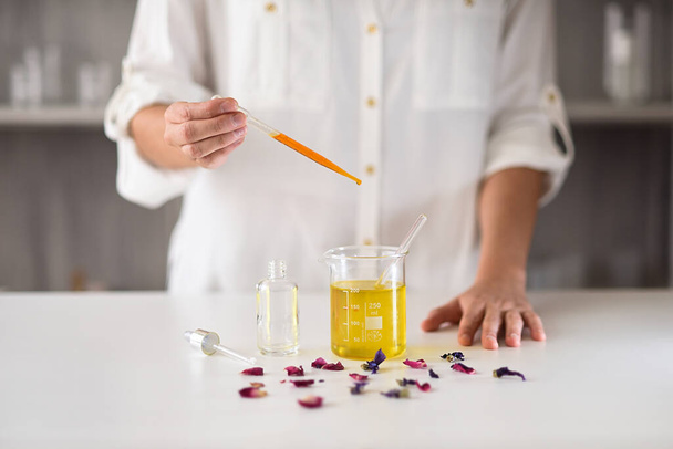 Ręce kobiet w naturalnym laboratorium kosmetycznym produkującym serum olejku eterycznego - Zdjęcie, obraz