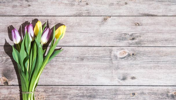 una postal de Pascua con tulipanes sobre una mesa de madera - Foto, imagen