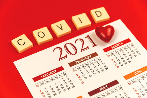 Día de San Valentín durante la pandemia de COVID-19, fondo con calendario 2021, inscripción y corazón rojo, foto - Foto, Imagen