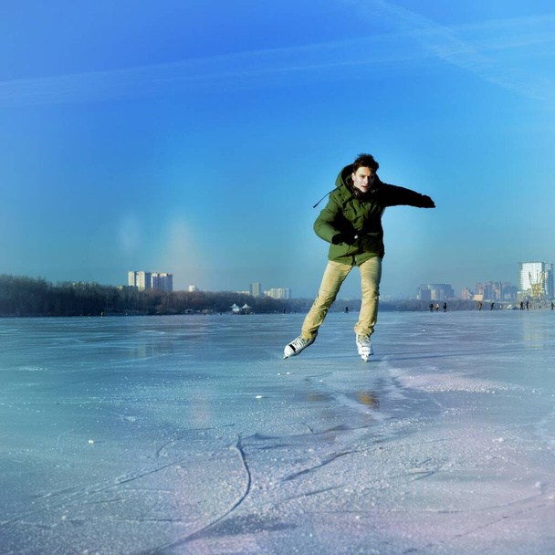 Matin sur la rivière gelée. Jeune homme patineur unique. - Photo, image