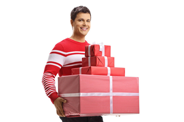 Guy in a sweather holding a pile of presents isolated on white background - Foto, Bild