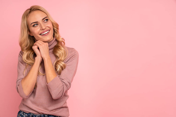 Portrait of a lovely young casual girl looking away isolated over pink background. - Foto, Imagen