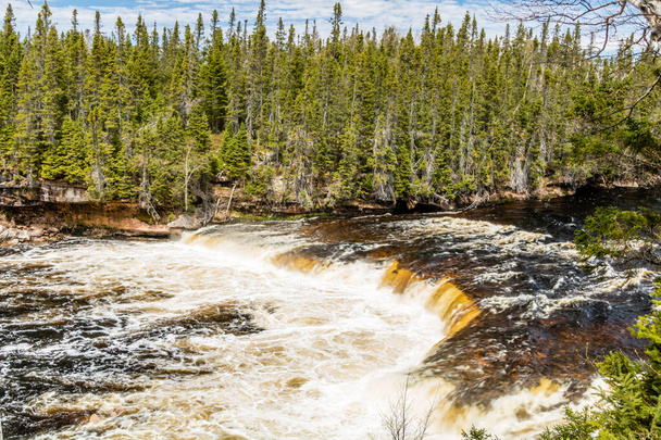 大きな滝が川の幅全体に広がっています。サー・リチャードはカナダのニューファンドランド州の州立公園を必要とします - 写真・画像