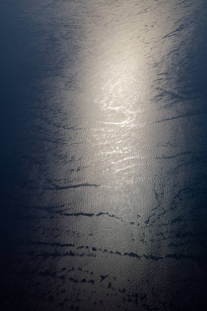 Lumière du soleil scintillant et réfléchissant l'eau de mer. Brille sur l'eau. Soleil réfléchissant à la surface de l'océan, vue de l'avion, concept de voyage.  - Photo, image