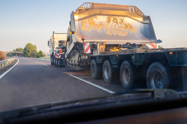 Camion lourd transportant un bulldozer. Des transports lourds. Vue de l'intérieur de la voiture - Photo, image