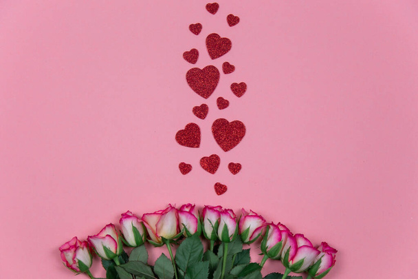 Τριαντάφυλλα με κόκκινες καρδιές σε ροζ φόντο Φεβρουάριος 14 Ημέρα του Αγίου Βαλεντίνου - Φωτογραφία, εικόνα