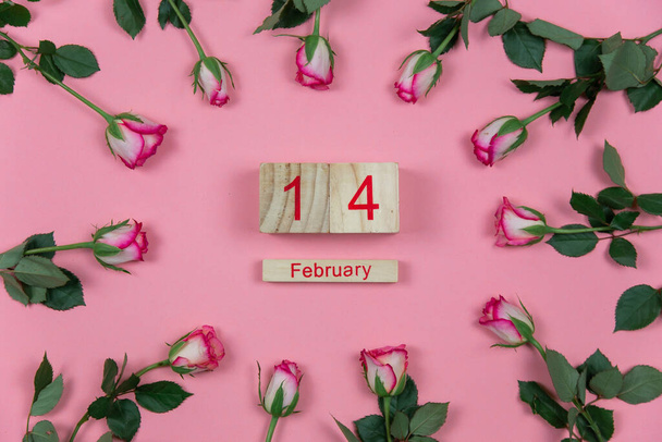 Розы с вином и деревянный календарь на розовом фоне 14 февраля День Святого Валентина - Фото, изображение
