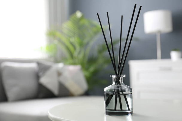 Aromatic reed air freshener on white table in room. Space for text - Фото, зображення