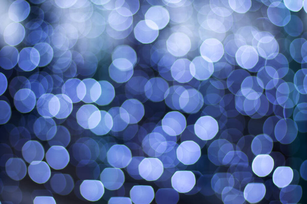 Defokted karácsony és újév bokeh fények, nagy elvont elmosódott bokeh, fényes koszorú fehér és kék színek, ünnepi háttér ünnepek. Karácsonyi izzás. - Fotó, kép