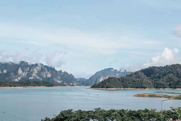 Beautiful mountains lake river sky and natural attractions in Cheow Lan lake, Ratchaprapha Dam, Khao Sok National Park in Thailand in a summer day - 写真・画像