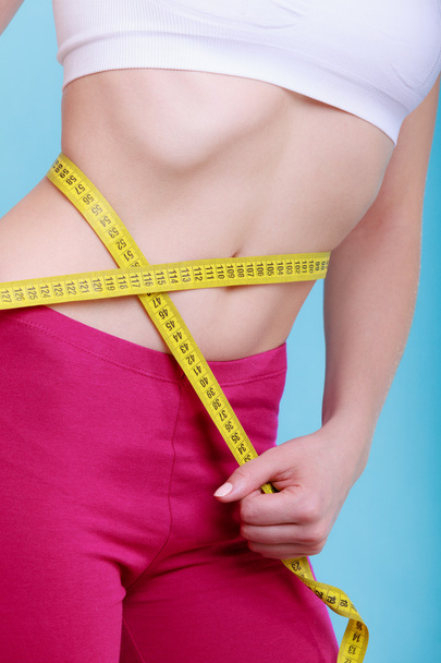 Diet. Fitness woman fit girl with measure tape measuring her waist - 写真・画像