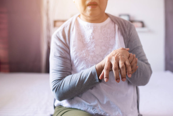 Elderly woman suffering with parkinson's disease symptoms on hand - Foto, immagini