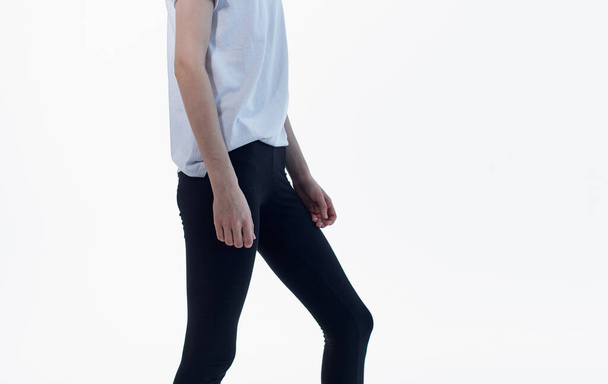 Black leggings white t-shirt woman light background gestures with hands - Foto, Imagem