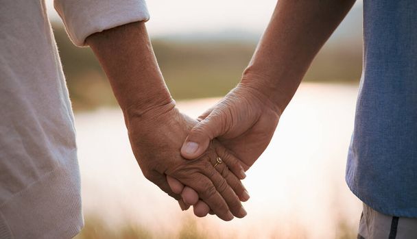 Concepto de amor y San Valentín. Una feliz pareja de ancianos tomados de la mano durante la puesta del sol, cuidado de la salud y relación. - Foto, imagen